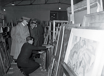 Adolph Hitler examining stolen artworks.